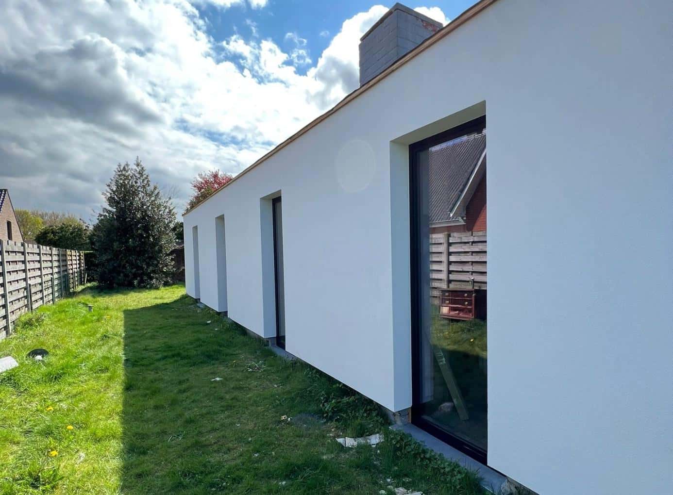 Witte crepigevel met buitenmuurisolatie bij een woning in Kortrijk